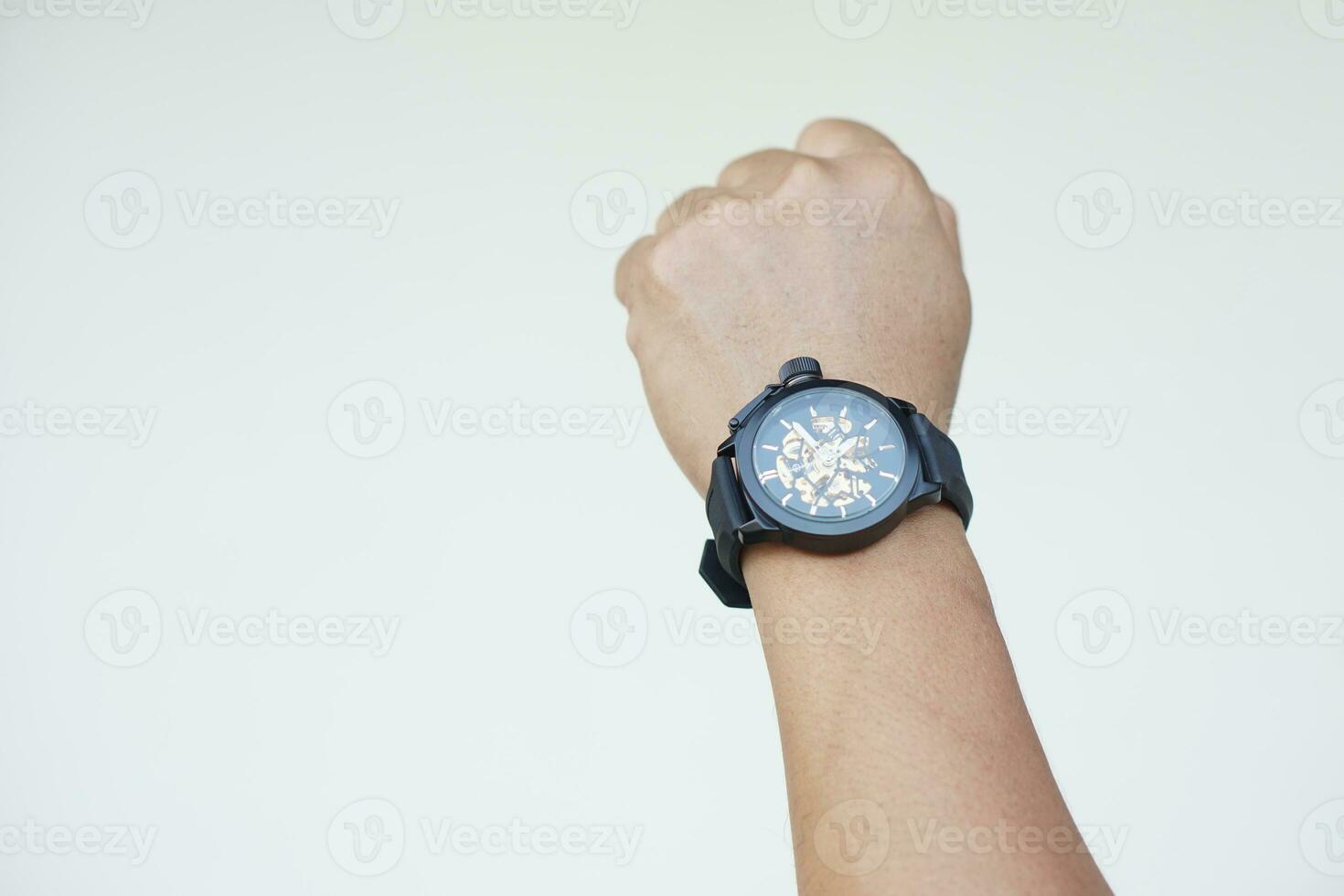 Close up man hand wears black watch againts gray wall background. Concept, fashionable accessory for time telling, make you look stylish, punctual and smart. Analog wrist watch. photo