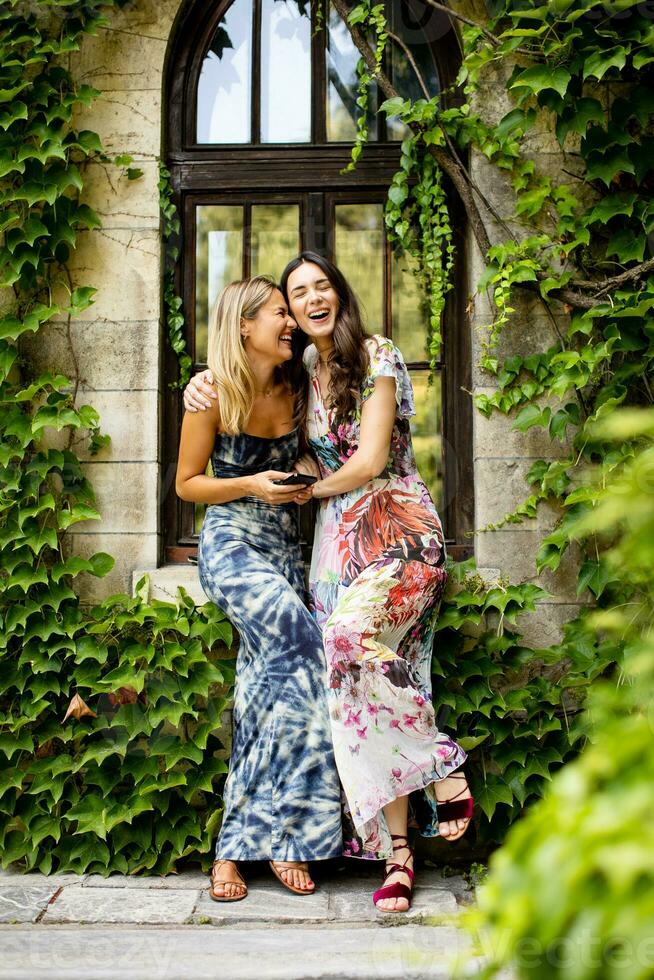 Pretty young women using mobile phone by the old house with ivy photo