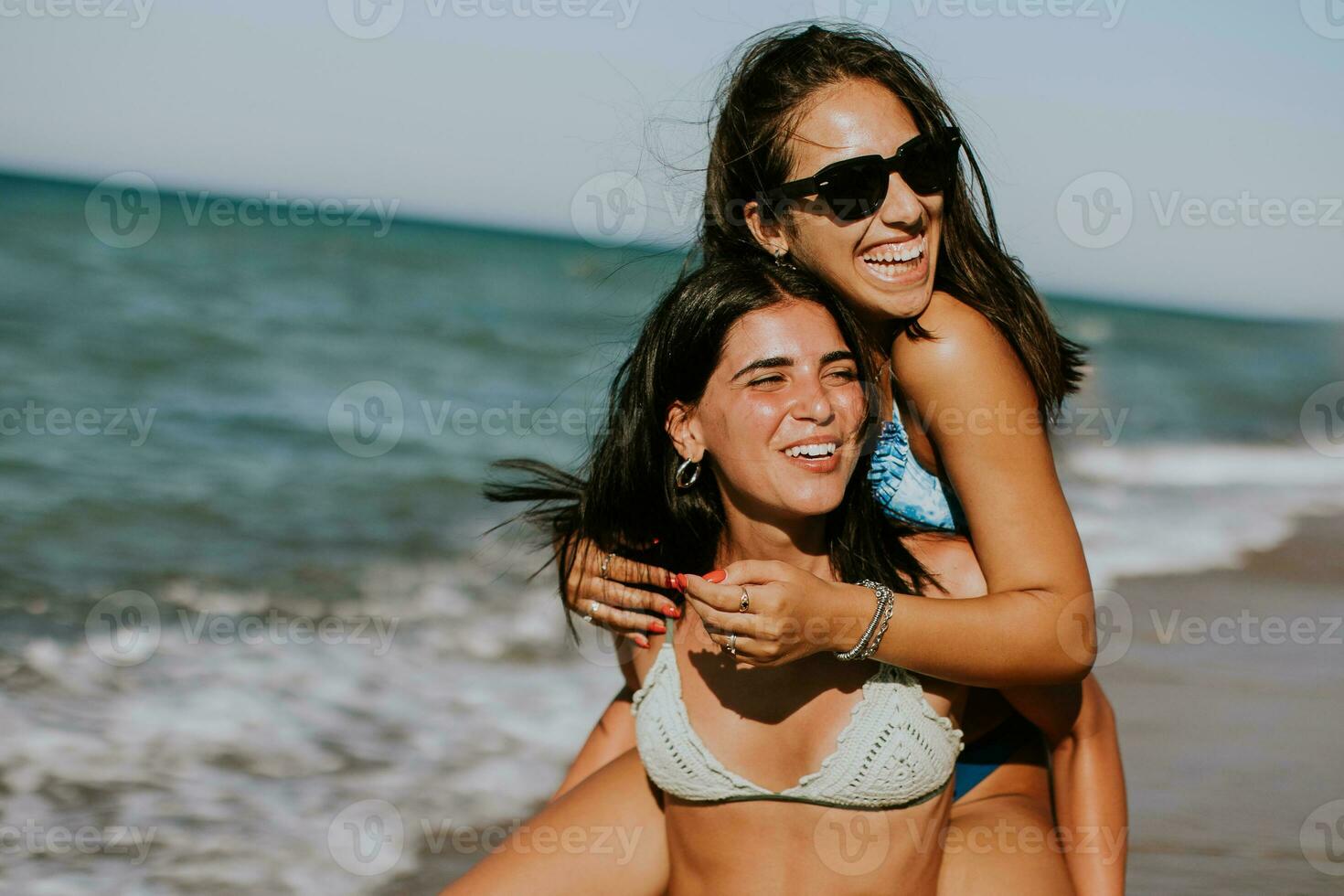 Two pretty young woman having fun on the seaside photo