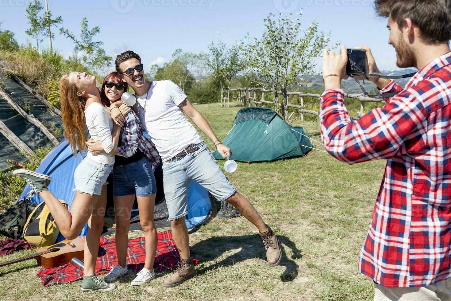 group of friends on vacation takes photos at the campsite