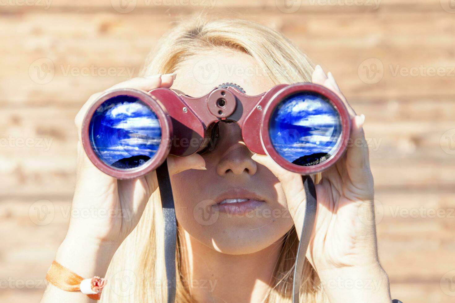 pretty girl with binoculars looking at the horizon photo