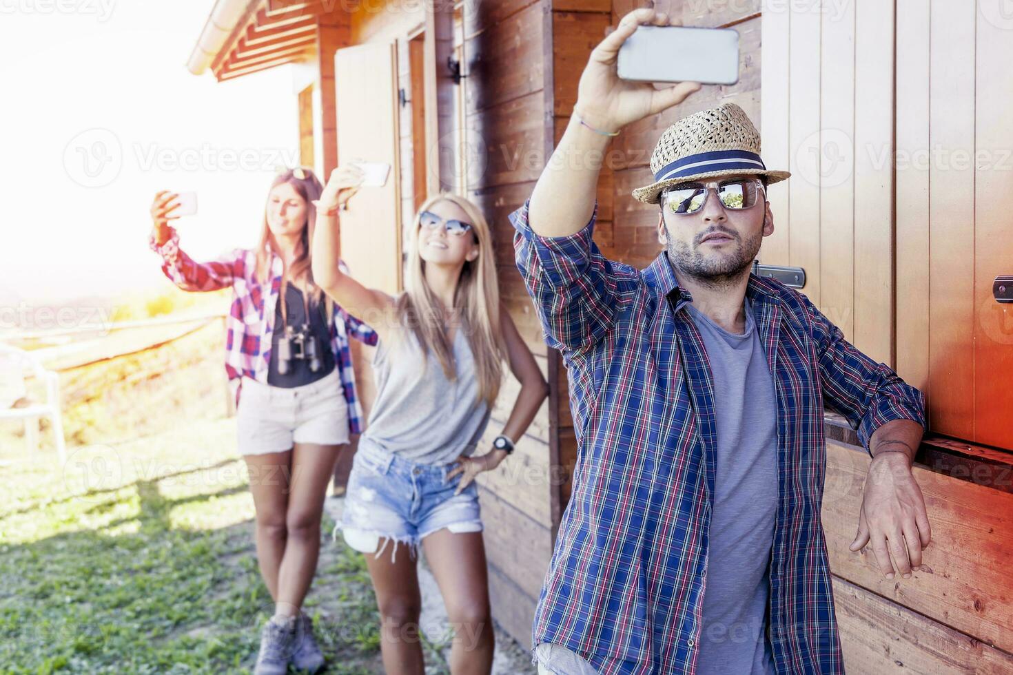 group of smiling friends in single file taking funny selfie with smart phone photo