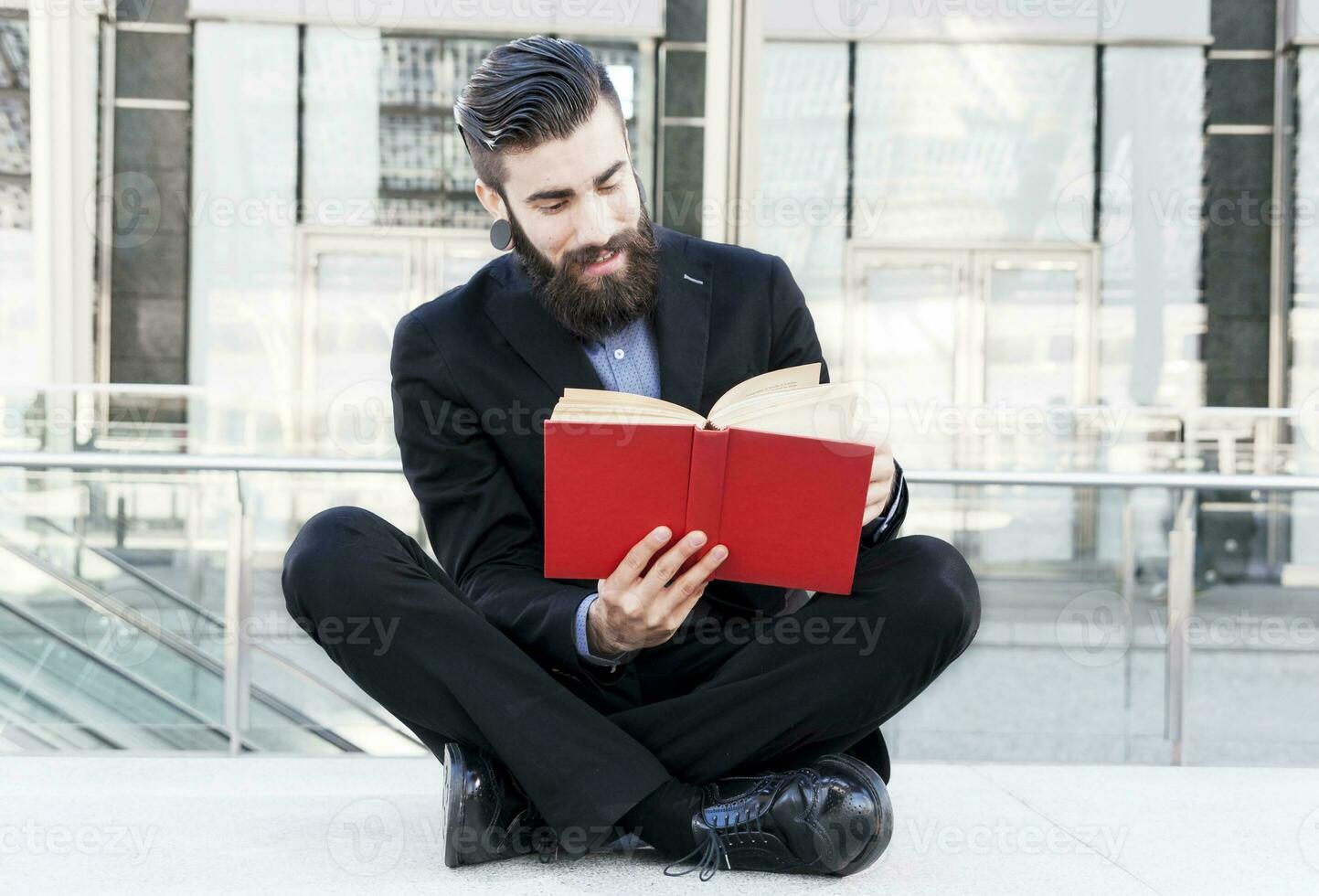 joven inconformista leyendo un libro sentado al aire libre foto