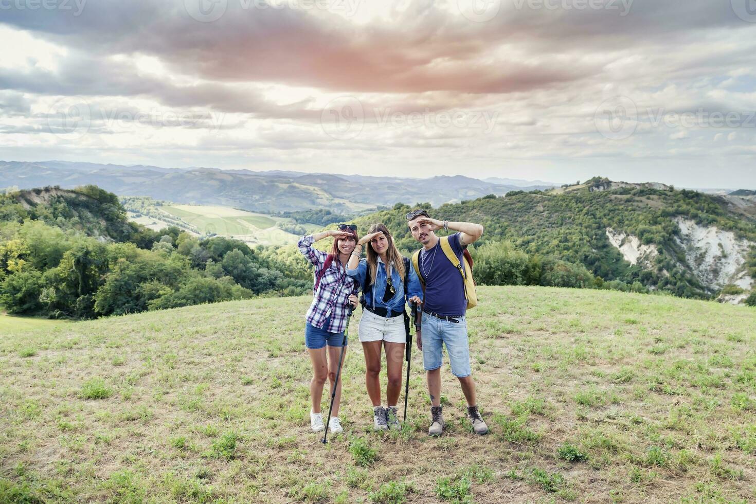 group of young adults looks to the horizon during hiking photo