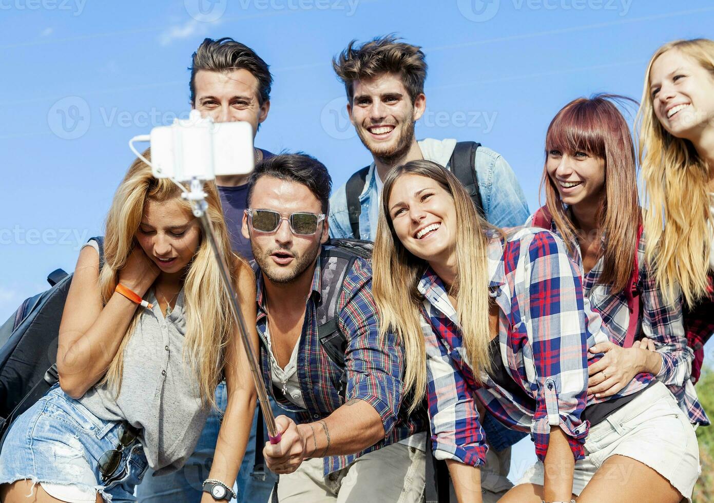 group of friends taking a self portrait with selfie stick photo