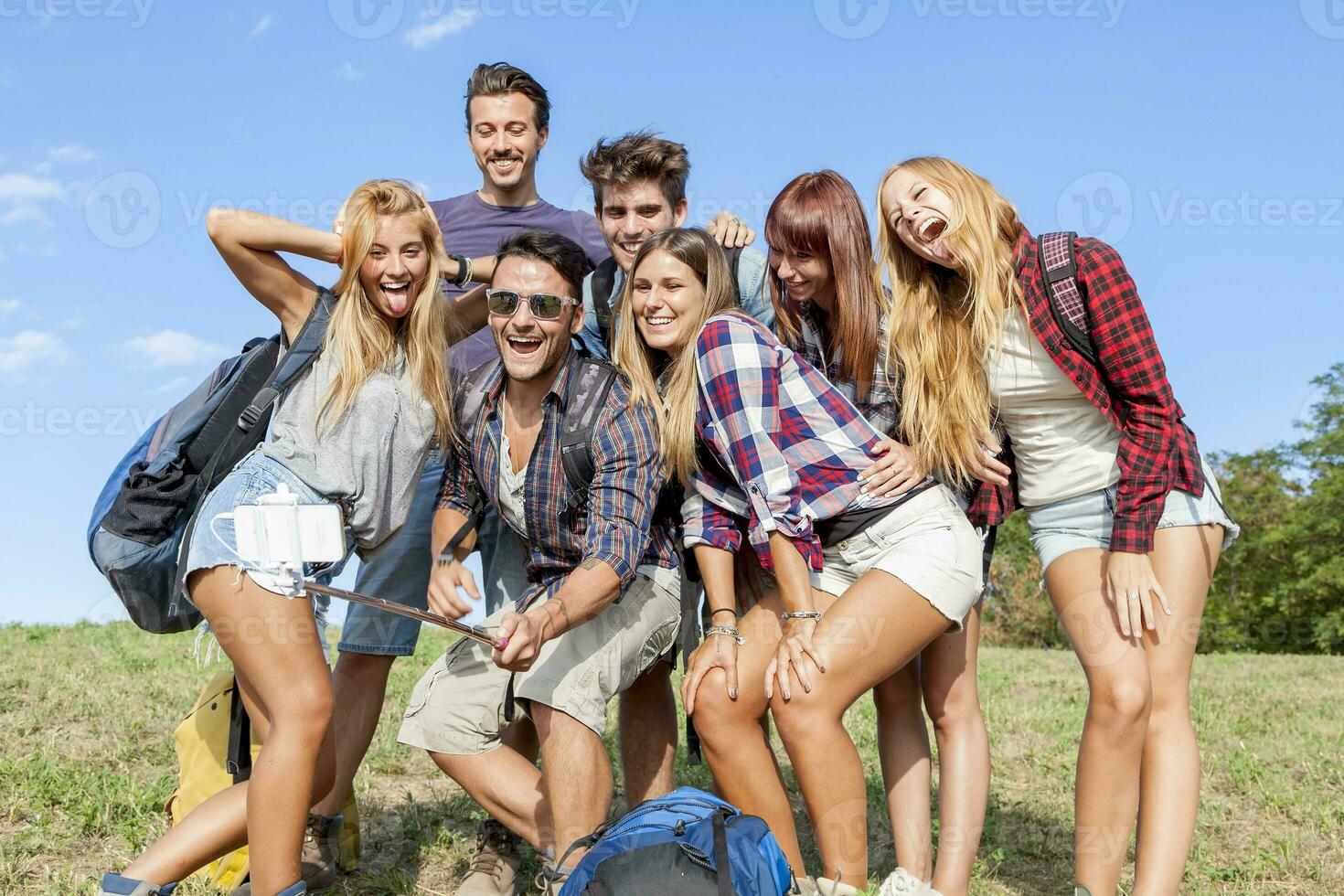 group of friends taking a self portrait with selfie stick photo