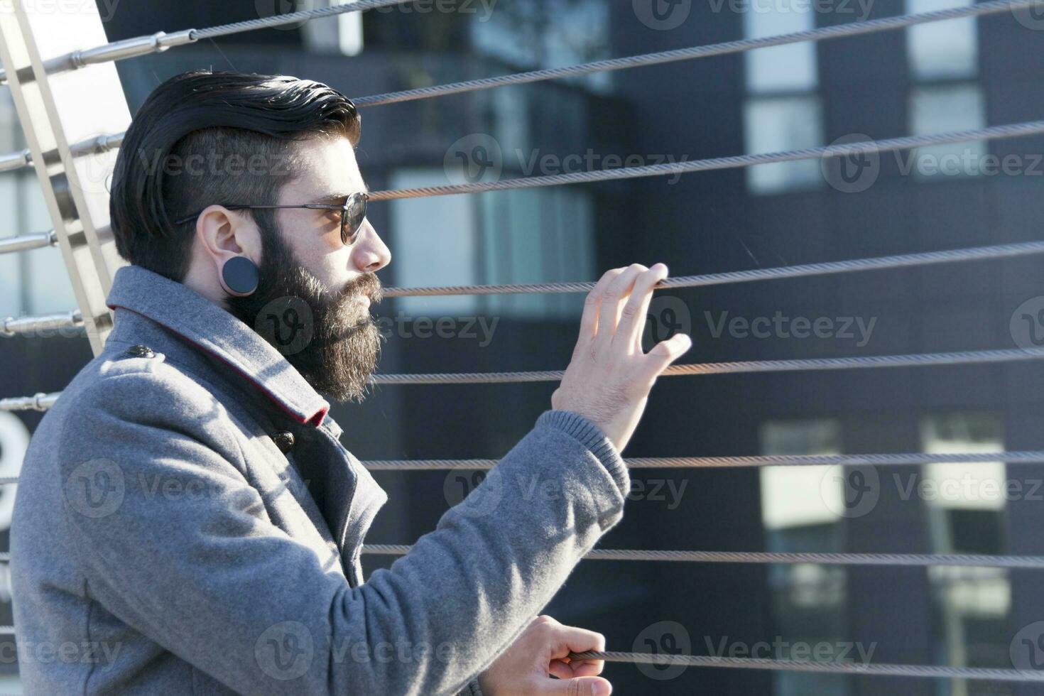 young hipster businessman look at traffic on an iron bridge photo