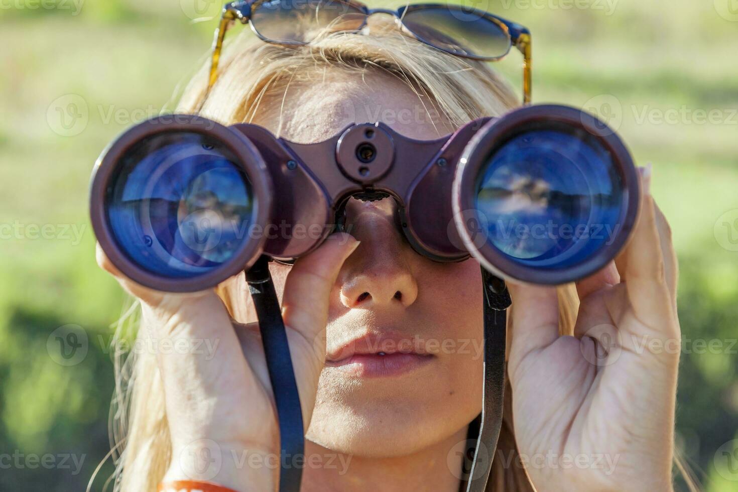 pretty girl with binoculars looking at the horizon photo