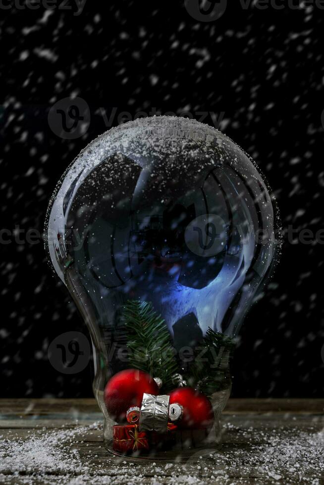 Christmas decorations inside a big light bulb under the snow photo