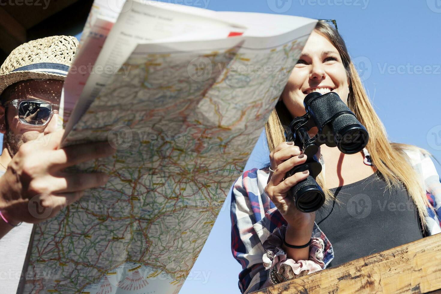 group of young hikers looking at map in the mountain photo