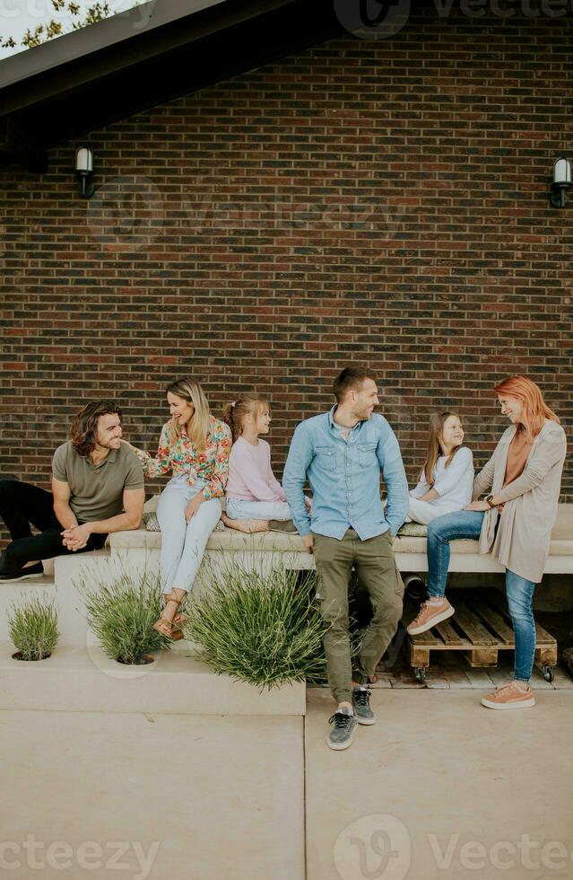 Group of young people and kids having good time in the house backyard photo