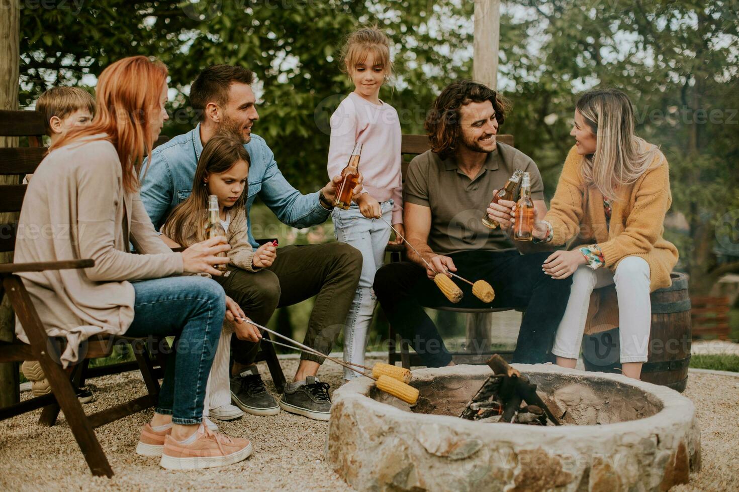 Friends having good time and baking corns in the house backyard photo