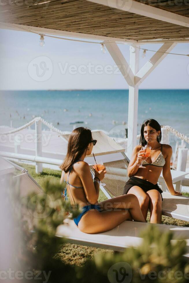 Smiling young women in bikini enjoying vacation on the beach photo