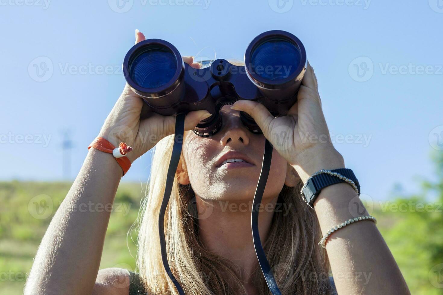 pretty girl with binoculars looking at the horizon photo