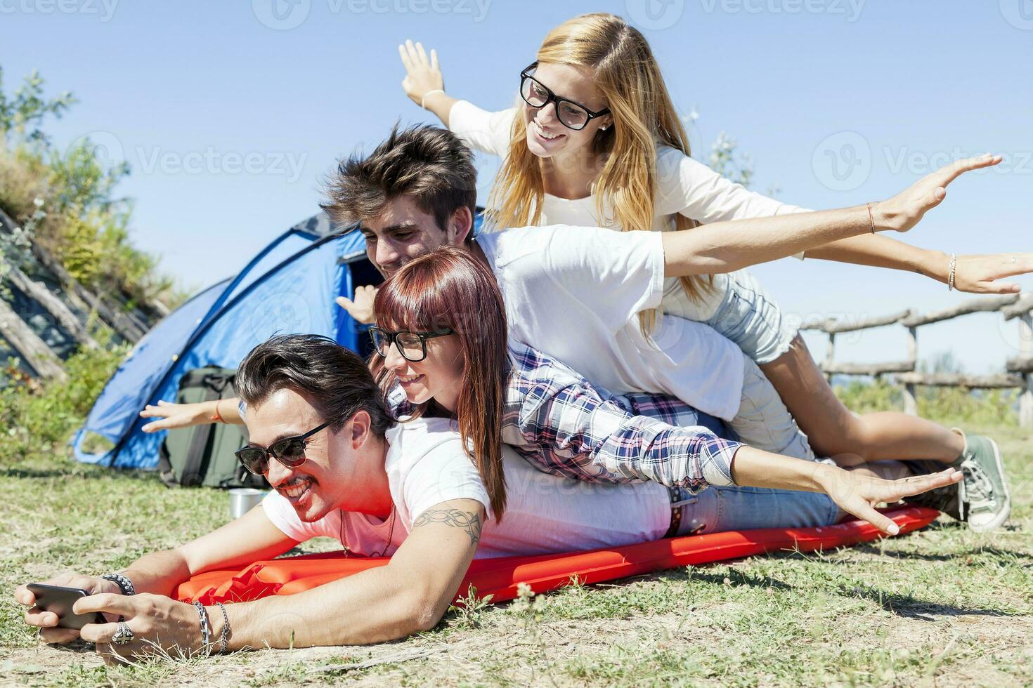 young boys and girls in campsite piled up smiling photo