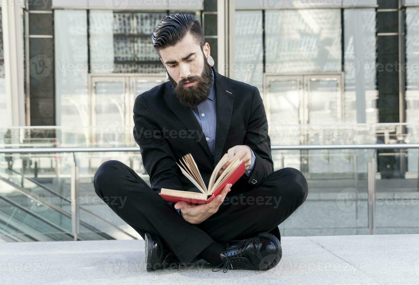 joven inconformista leyendo un libro sentado al aire libre foto