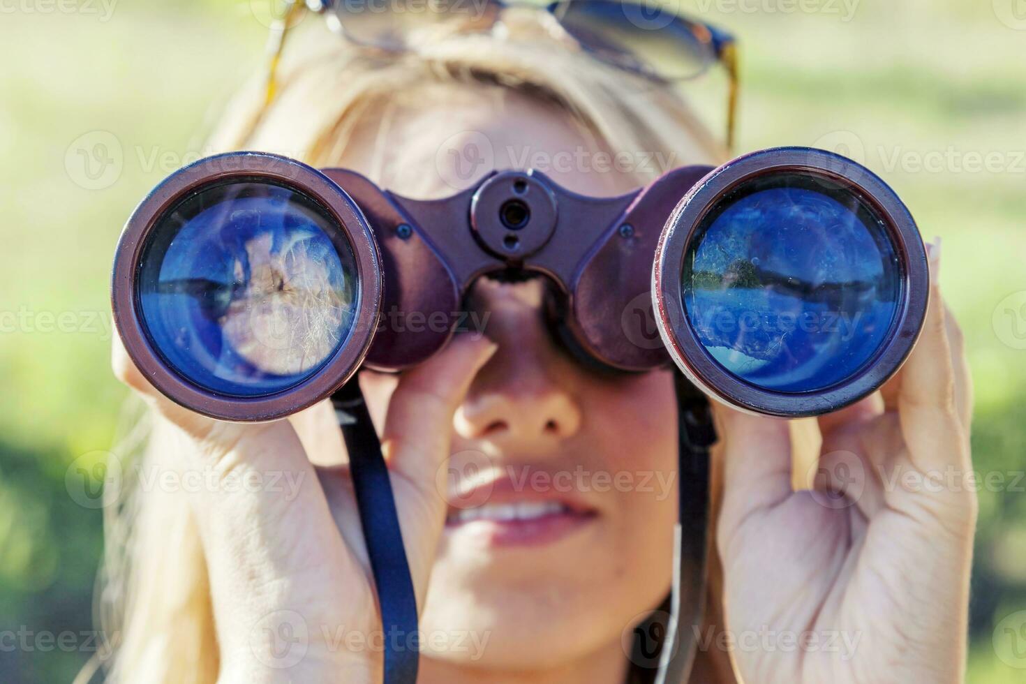 pretty girl with binoculars looking at the horizon photo