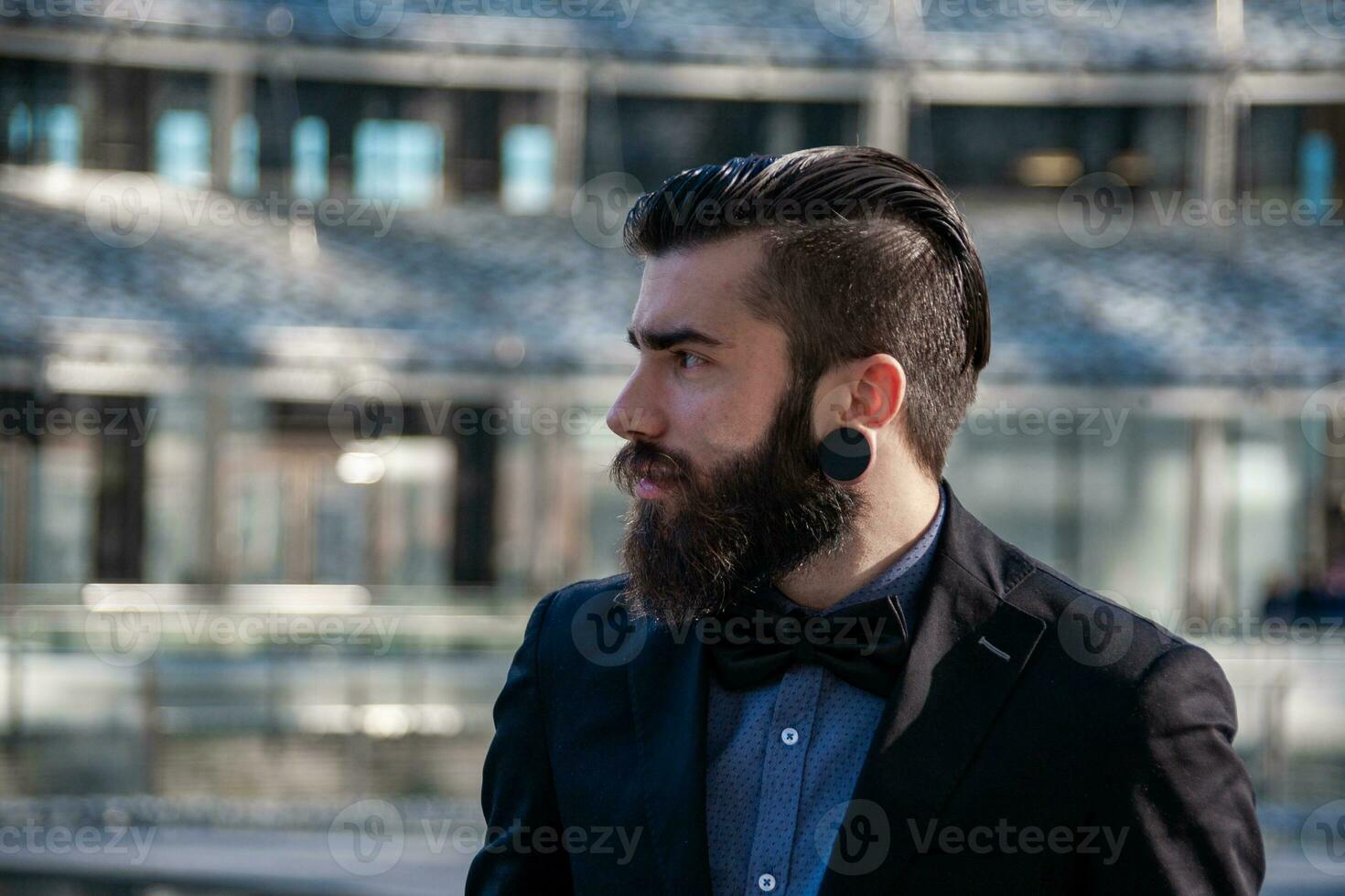 portrait of young stylish hipster outdoors traveling through a capital photo