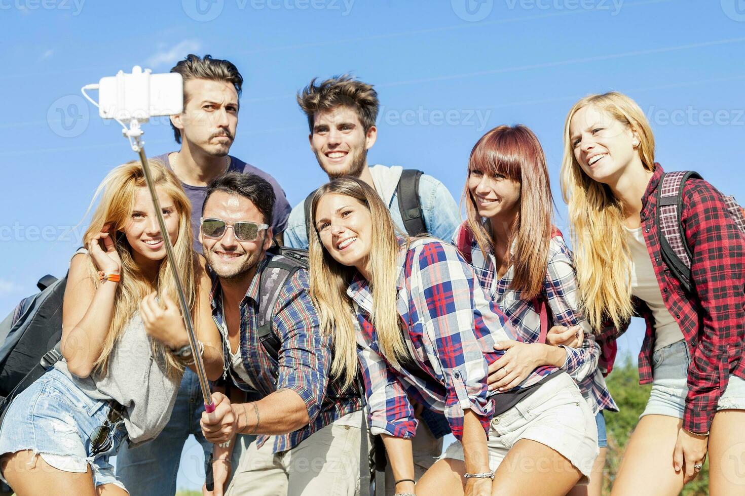 group of friends taking a self portrait with selfie stick photo