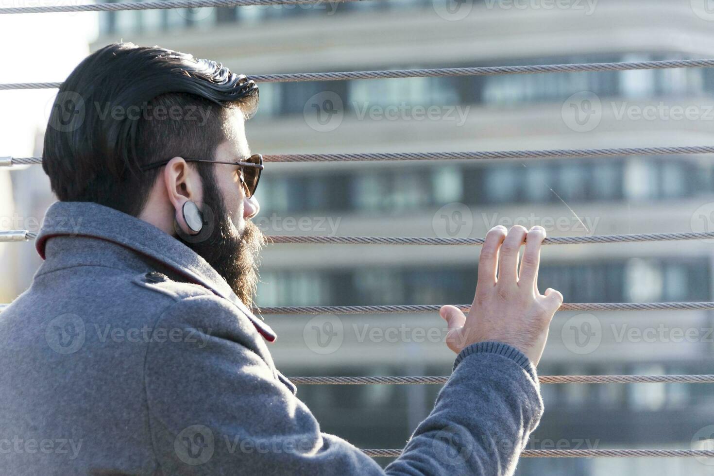 young hipster businessman look at traffic on an iron bridge photo