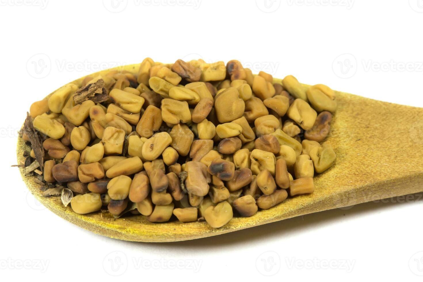 Fenugreek seeds on wooden spoon photo