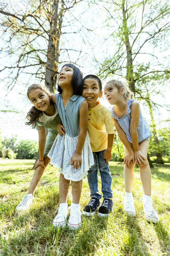 grupo de niños asiáticos y caucásicos divirtiéndose en el parque foto