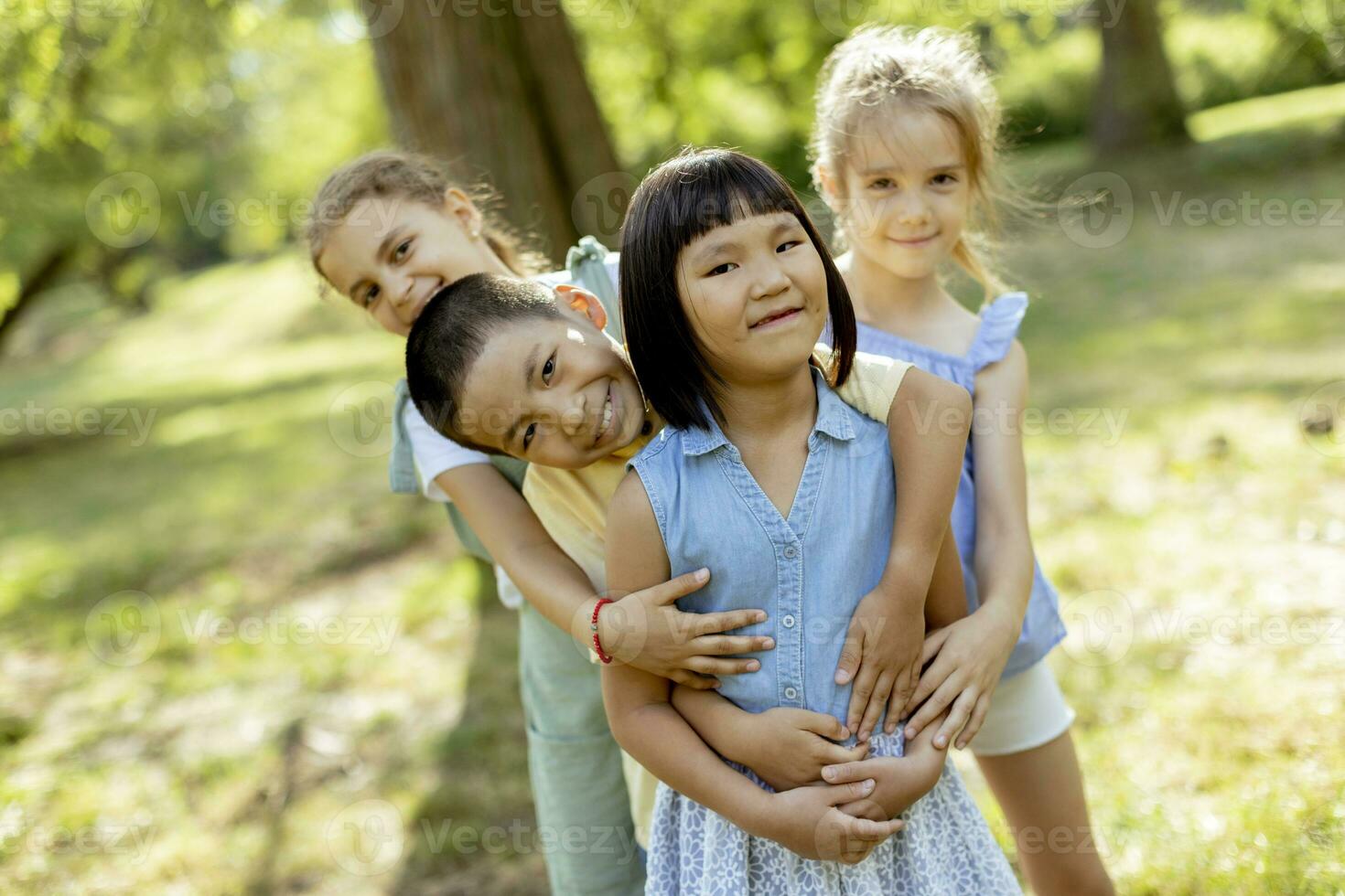 grupo de niños asiáticos y caucásicos divirtiéndose en el parque foto