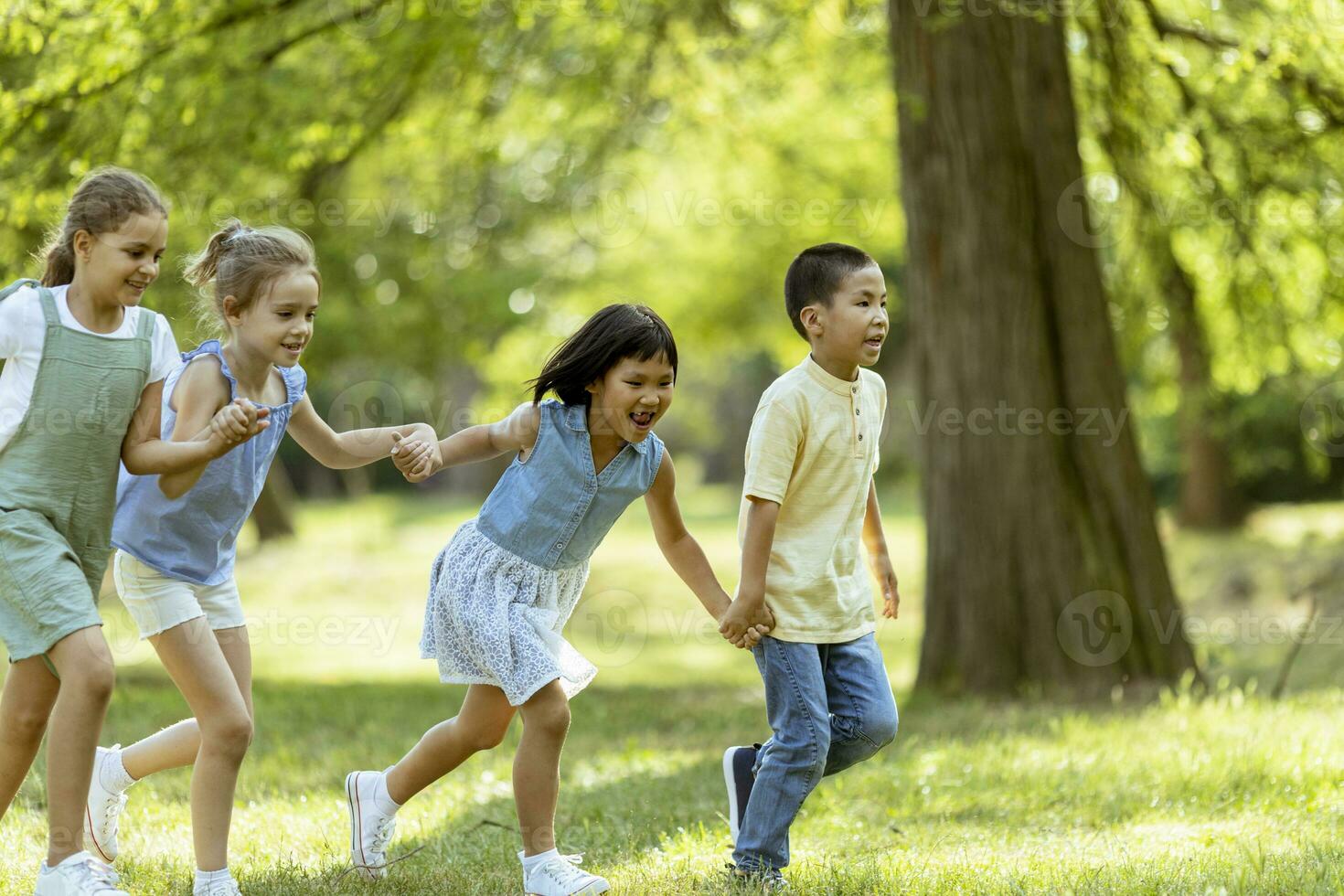 grupo de niños asiáticos y caucásicos divirtiéndose en el parque foto