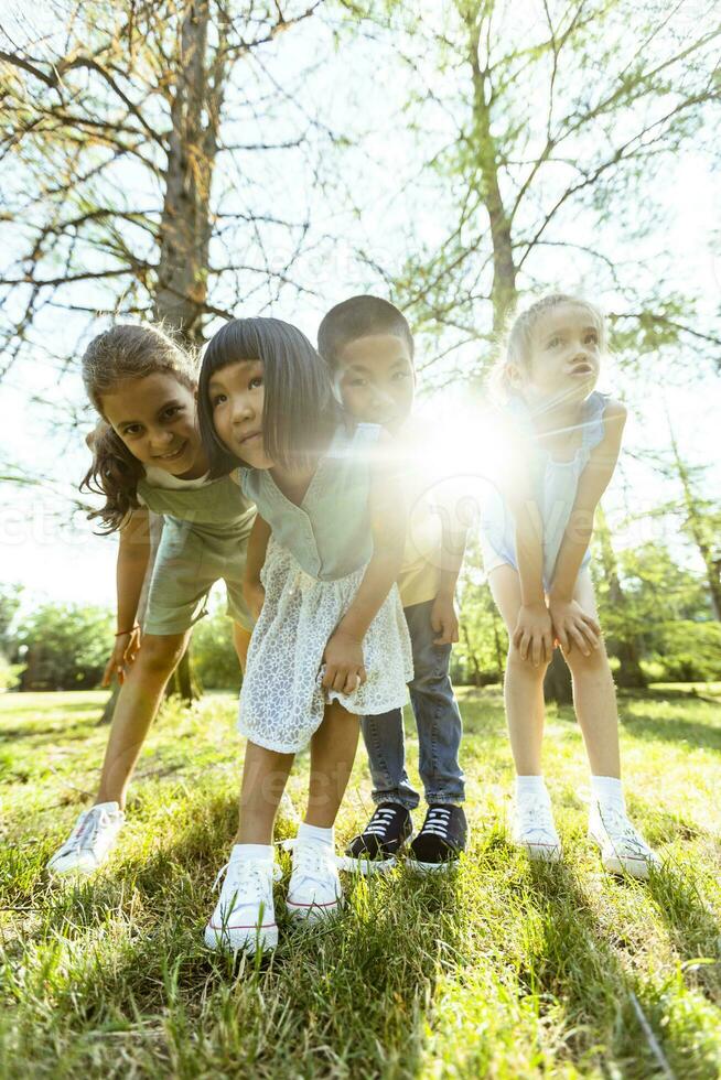 Group of asian and caucasian kids having fun in the park photo