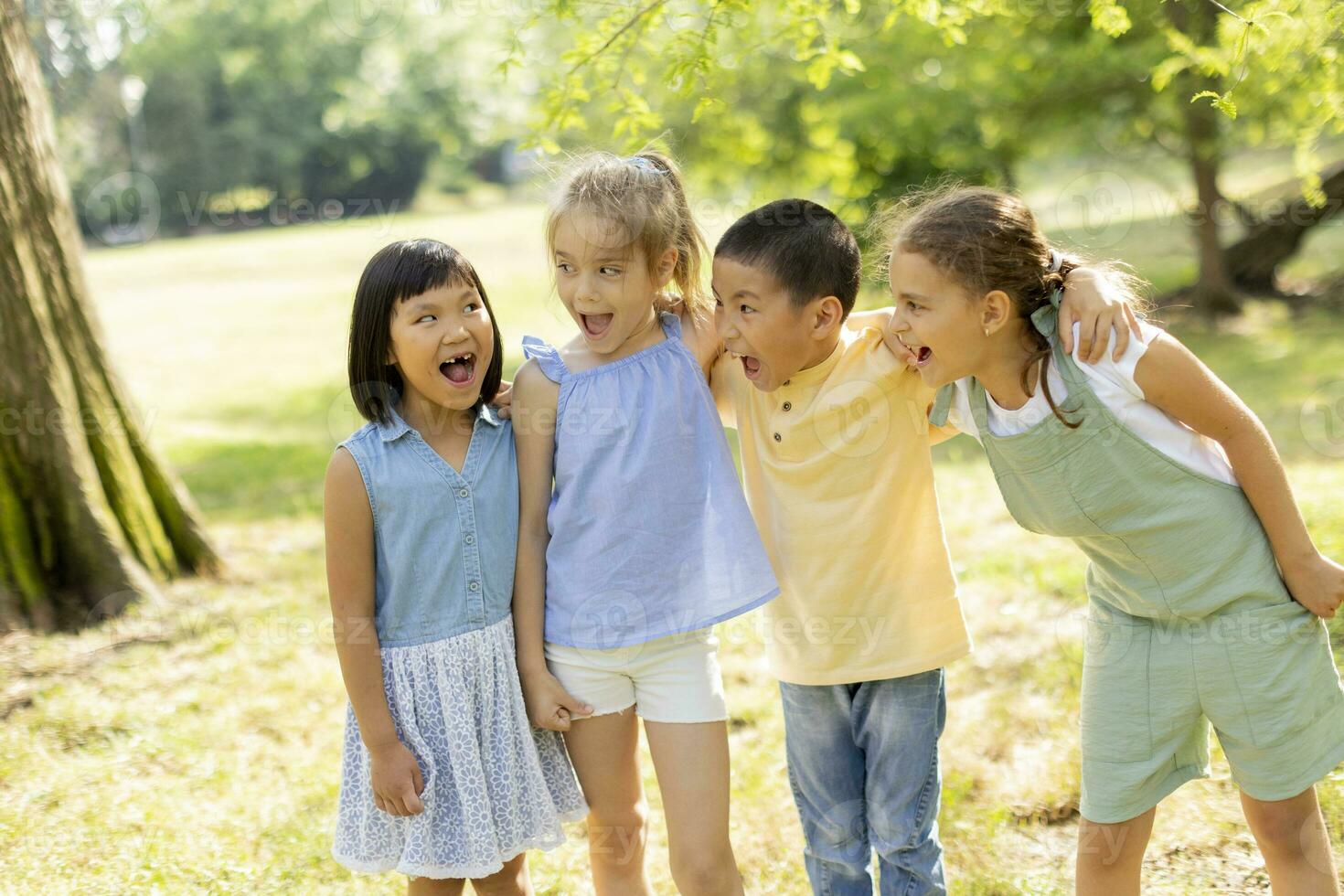 grupo de niños asiáticos y caucásicos divirtiéndose en el parque foto