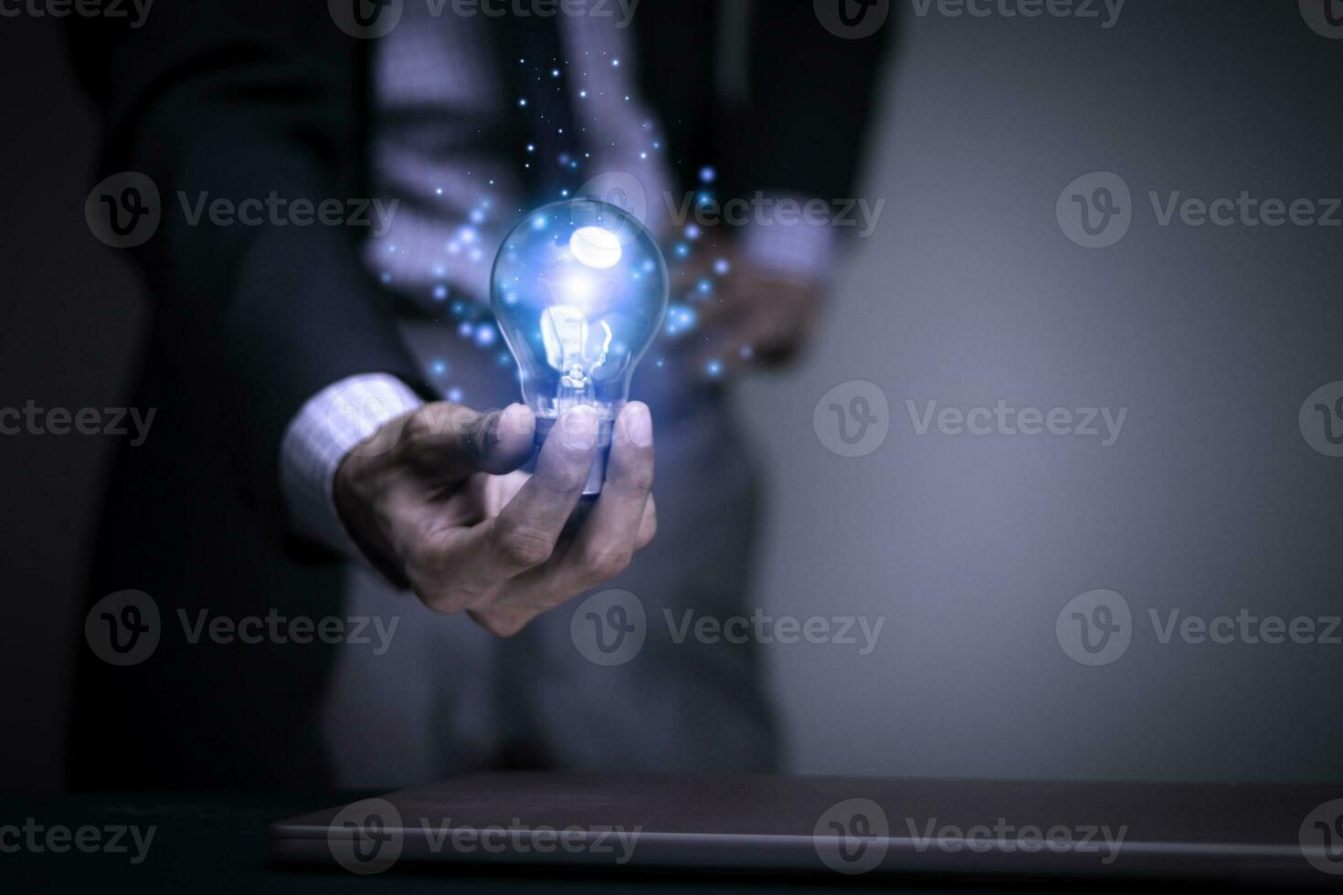 Businessman holding a light bulb creates new ideas. Innovation. Brainstorming. Solutions. And inspiration. Imagination. Creativity. Problem solving. Solution removing obstacles to success in business. photo