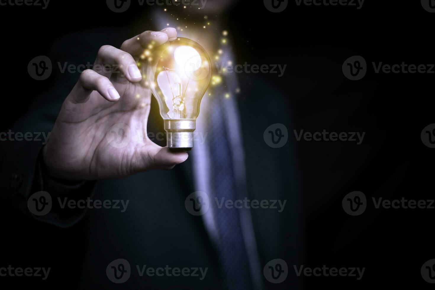 Businessman holding a light bulb creates new ideas. Innovation. Brainstorming. Solutions. And inspiration. Imagination. Creativity. Problem solving. Solution removing obstacles to success in business. photo