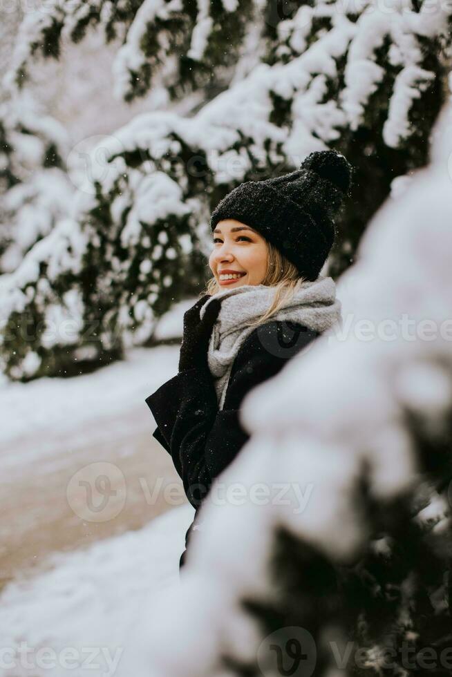 Young woman n warm clothes enjoying in snow photo