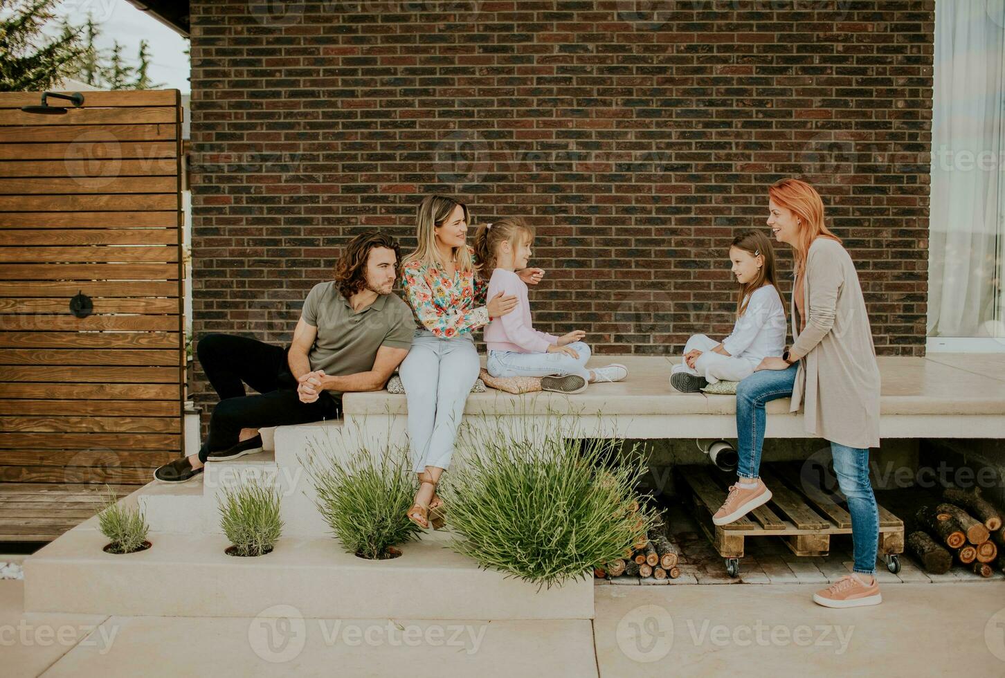 Group of young people and kids having good time in the house backyard photo