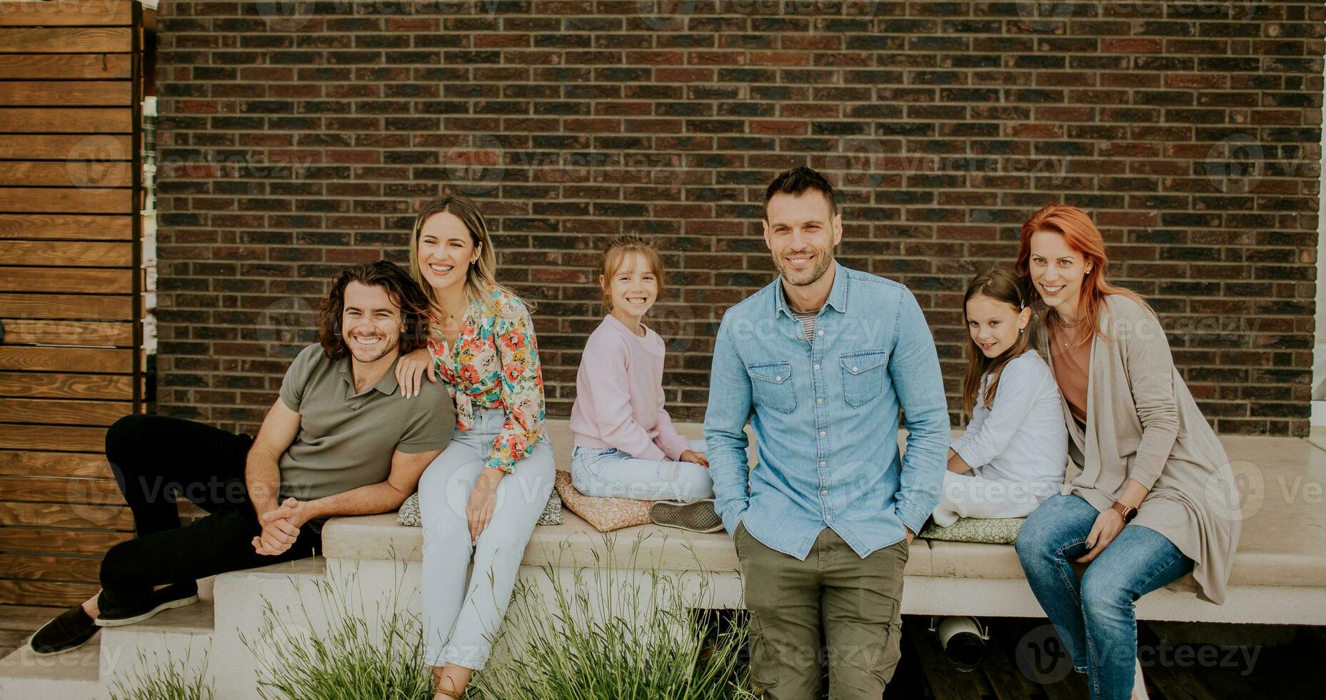 Group of young people and kids having good time in the house backyard photo