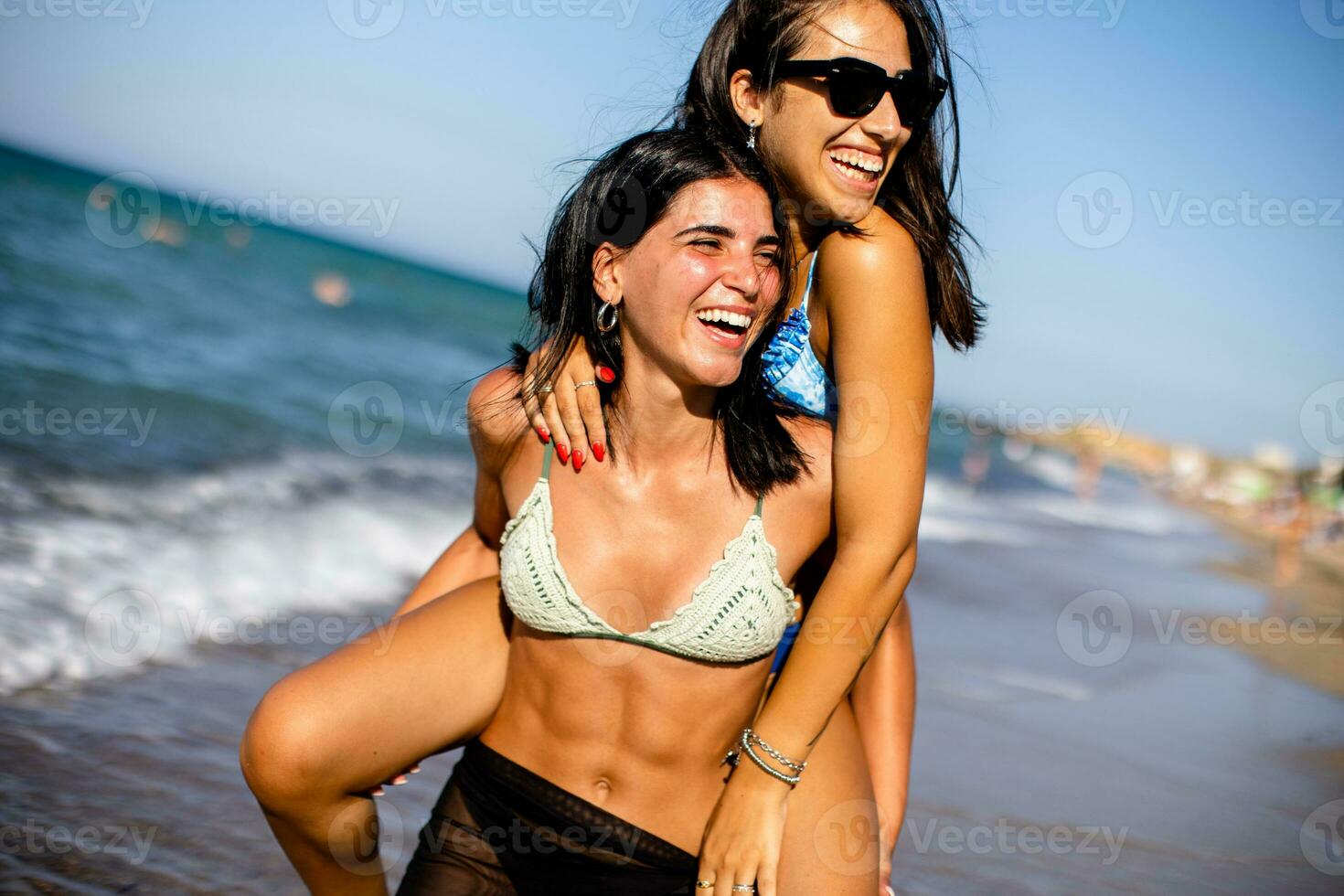 Two pretty young woman having fun on the seaside photo