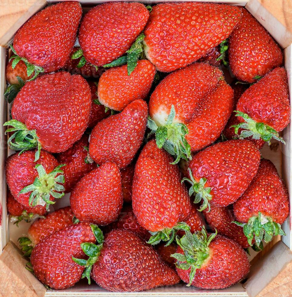 A wooden box filled with strawberries. photo