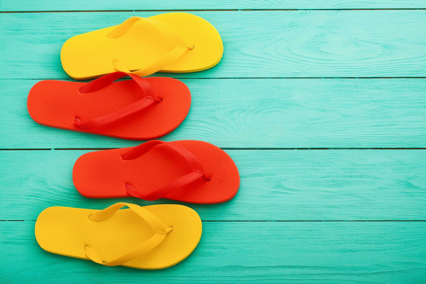 Colorful flip flops on blue wooden background with copy space. Top view photo