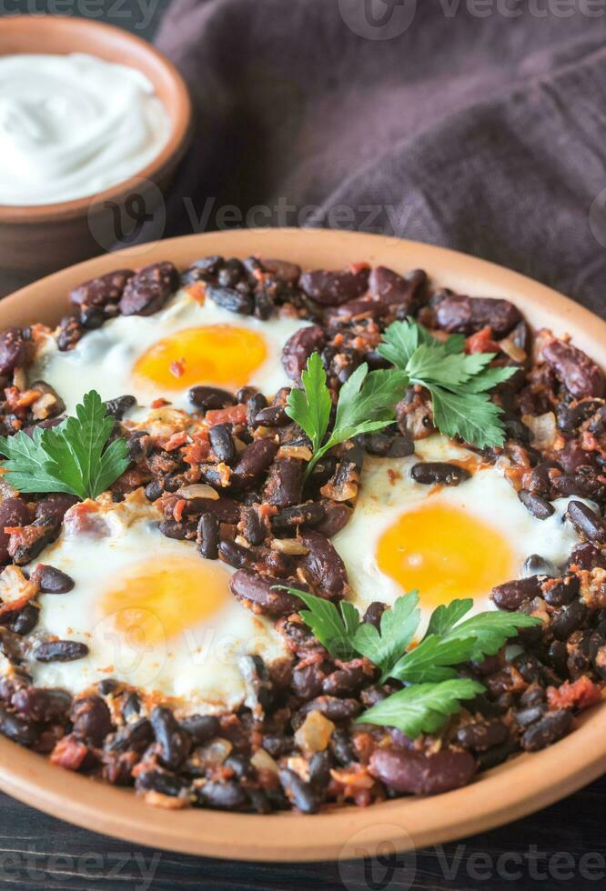 cuenco de chipotle frijol chile con horneado huevos foto