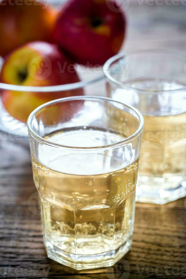 Two glasses of cider on the wooden background photo