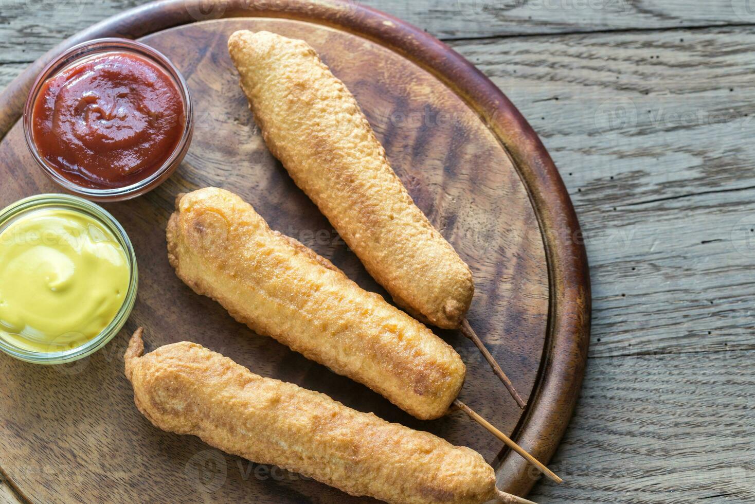 Stack of corn dogs on the wooden board photo