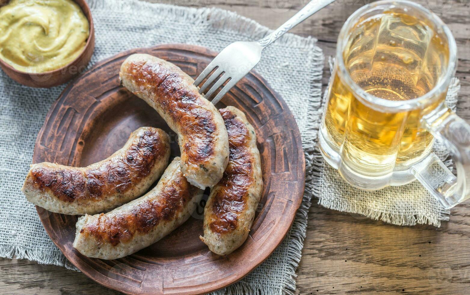 Grilled sausages with fried bacon rashers and mushrooms photo