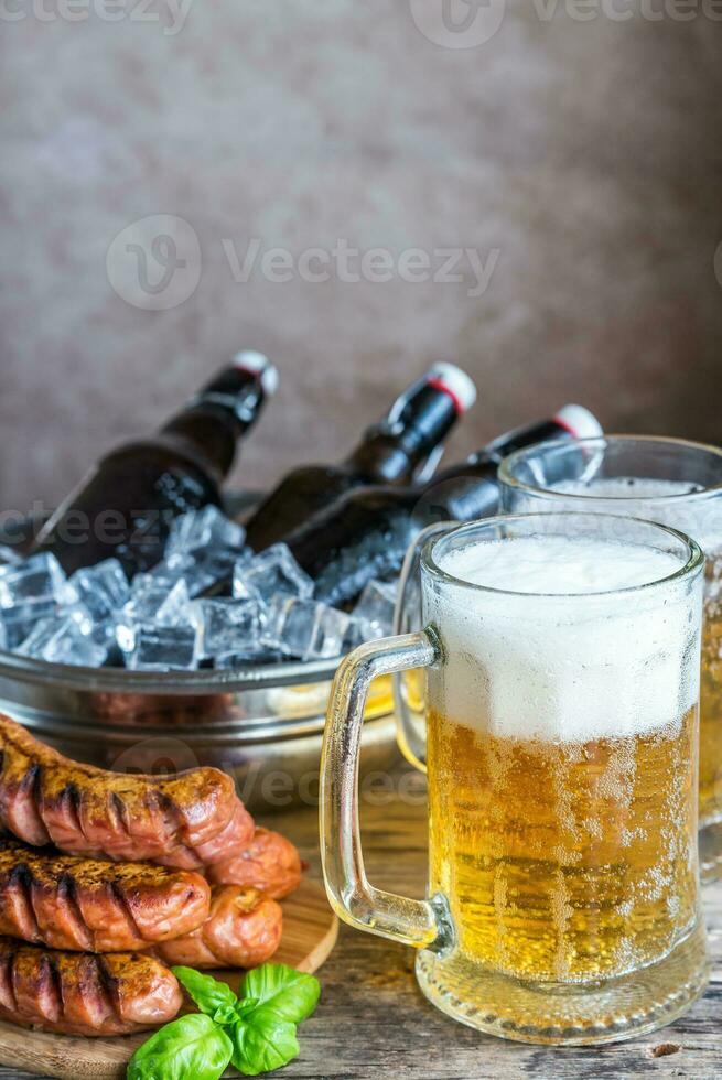 Grilled sausages  and mugs of beer photo