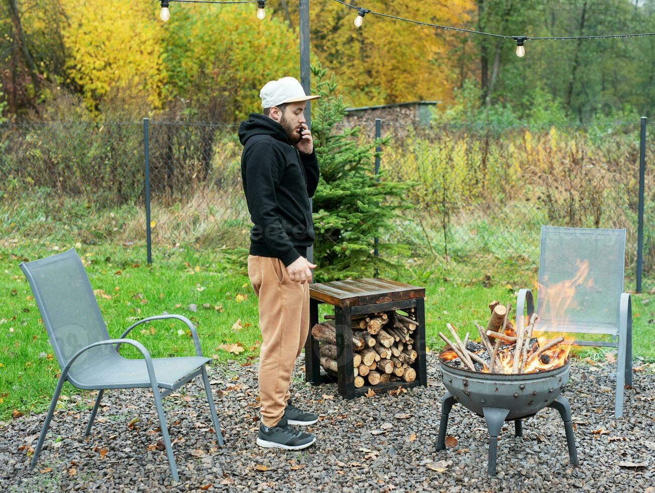A man lights a barbecue in nature photo