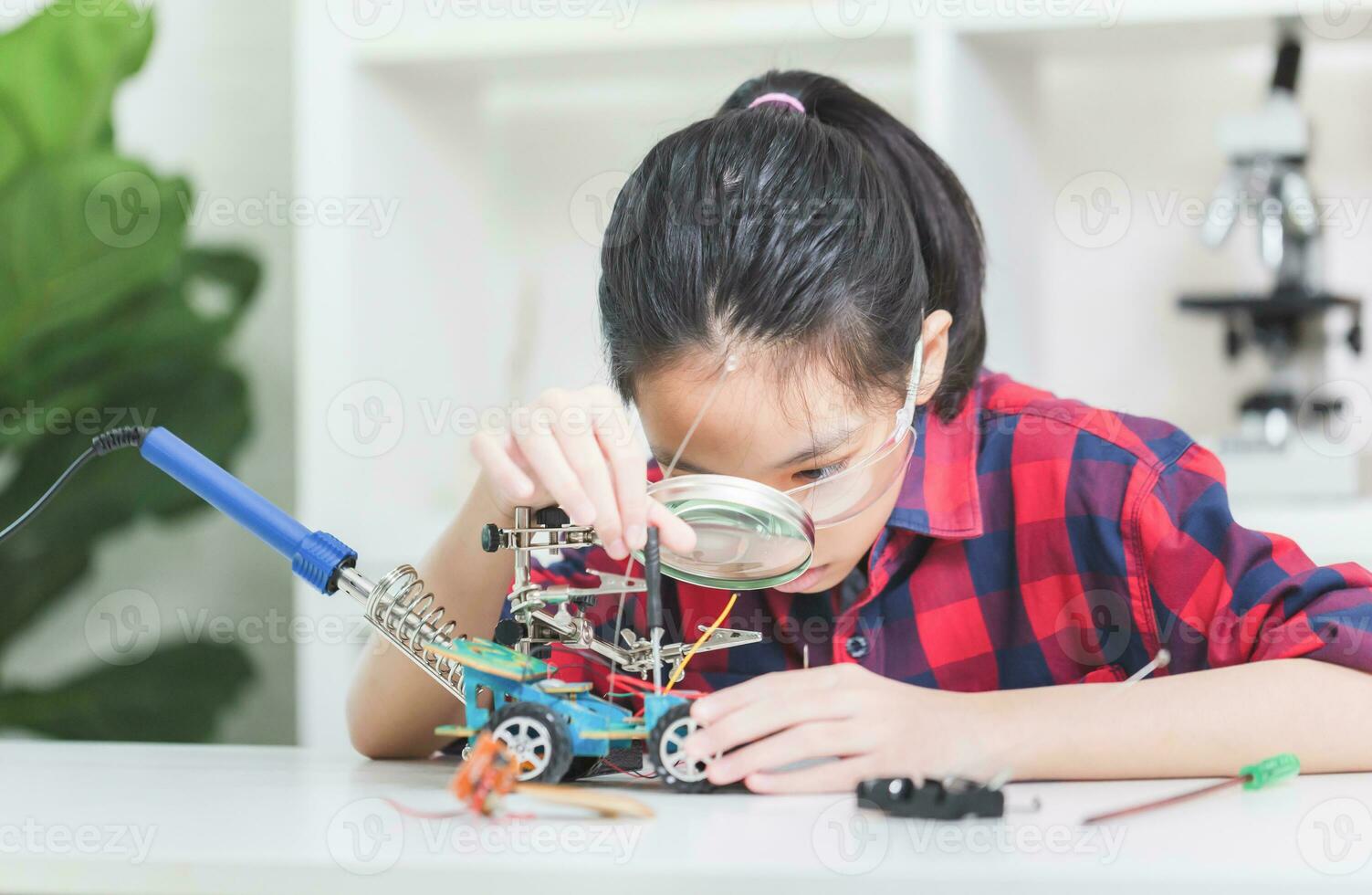 Asian child girl students build robotic cars, kids learn to program robot vehicles photo