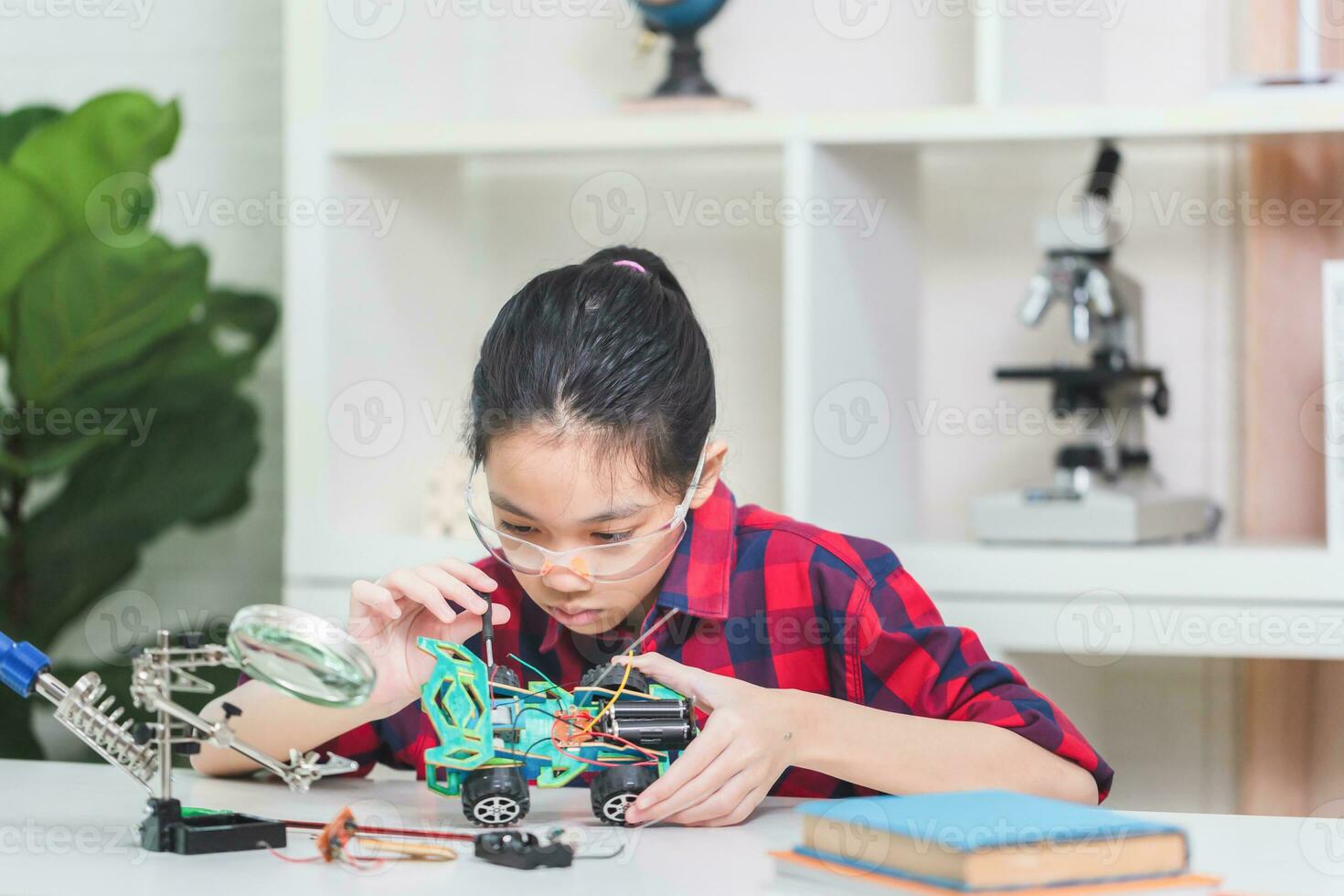 Asian child girl students build robotic cars, kids learn to program robot vehicles photo