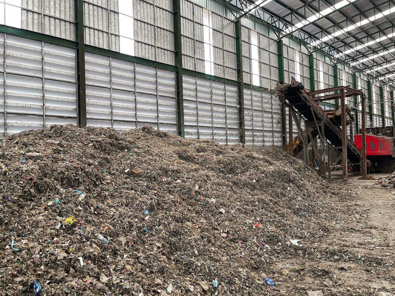 Mechanical sorting pile of mixed waste, deposited in the waste treatment plant depot, preparing it for separation. Waste disposal, management, reuse, recycle and recovery concept. photo