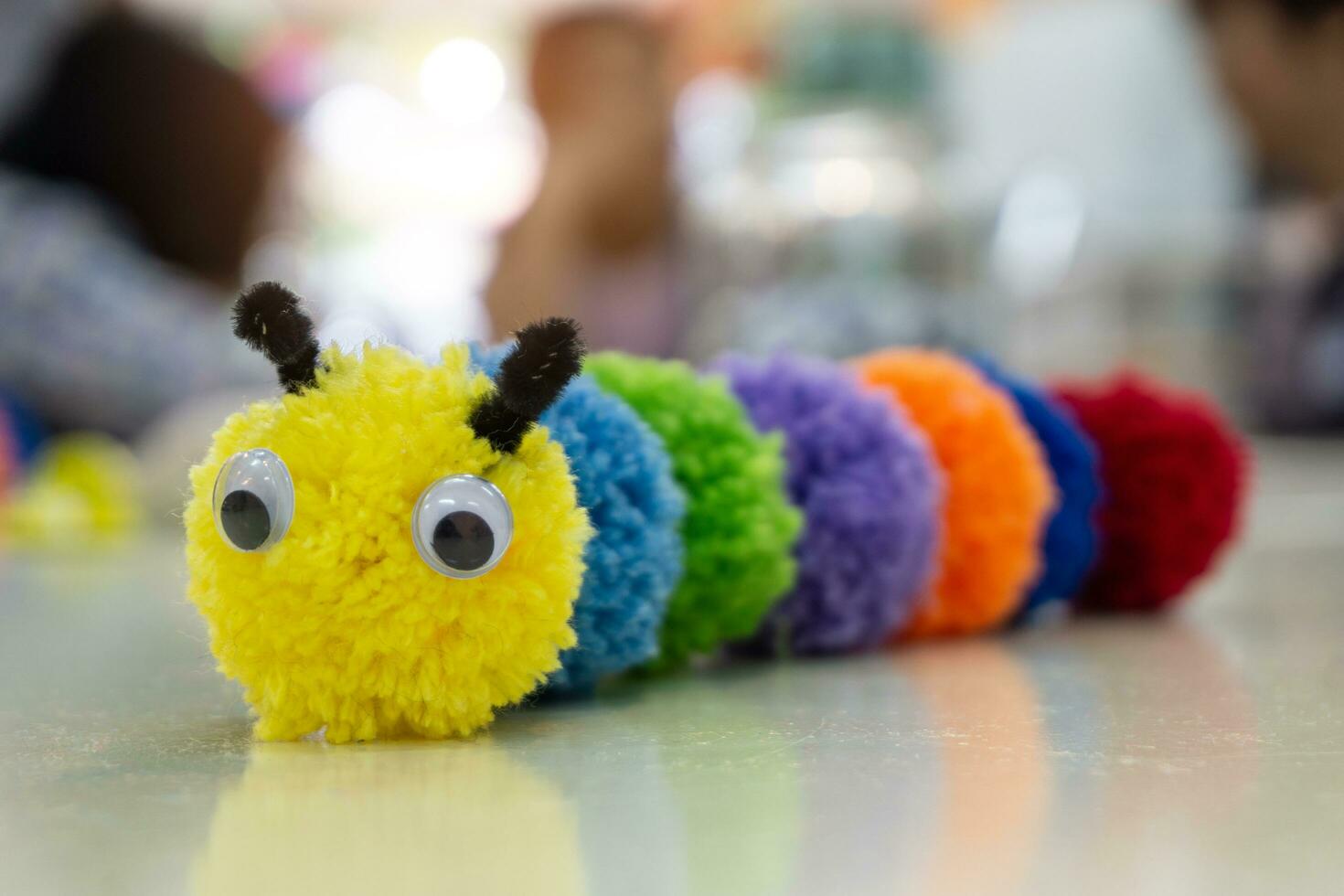 Handmade colorful worm doll and blurred background. photo