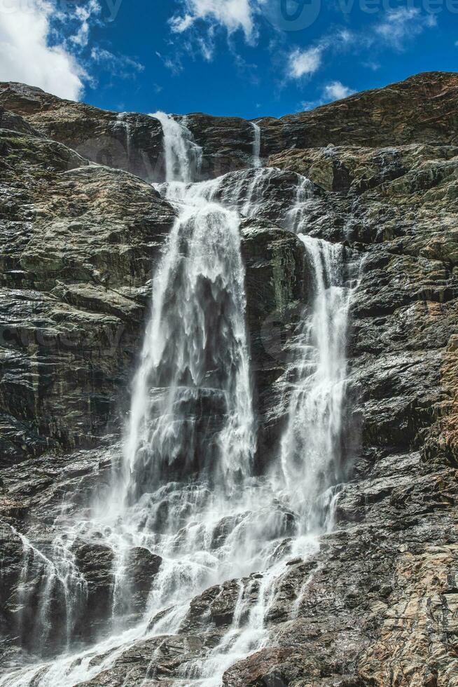 Great waterfall that goes down to the mountains photo