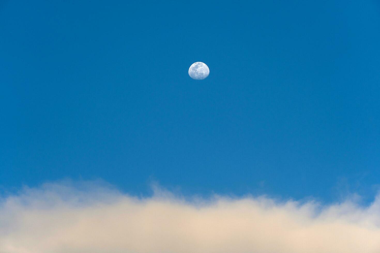 Day moon and strange clouds on the sky photo